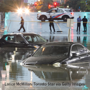 Two cars are trapped in floodwaters under an overpass on a street in Toronto on Sept. 2, 2026