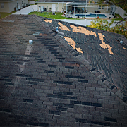 Storm-damaged asphalt shingle roof