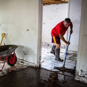 A man sweeps water from a house that was flooded (Photo by PATRICK HAMILTON/AFP /AFP via Getty Images)