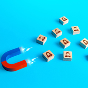 Magnet pulling wooden blocks with employee images, symbolizing talent poaching.
