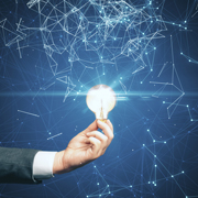 Hand holding lit lightbulb, connected network background