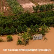 A house and trees surrounded by brown floodwaters in Hawaii in March 2026