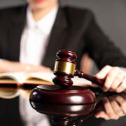 Young female judge working in courtroom. Law and justice symbols on the table. (Photo credit: Zolnierek)