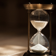 Sandglass, hourglass or egg timer on wooden floor with shadow