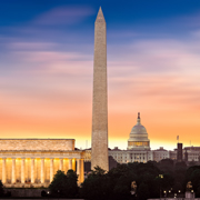Dawn over Washington with 3 iconic monuments illuminated at sunrise.