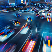 Cars moving through intersection at night.