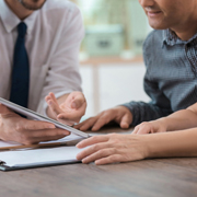An insurance salesperson showing a client paperwork