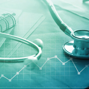 Stethoscope resting on medical charts with a data line graph.