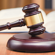 A wooden gavel and soundboard with a book in the background