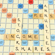 Scrabble tiles on a board spelling out life insurance and investing terms.