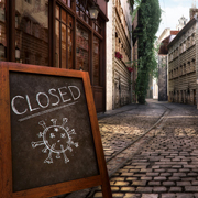 A "CLOSED" sign with a virus illustration on a street.