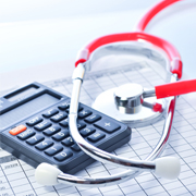 A calculator and a stethoscope on a clipboard.