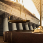Scales of Justice resting on a law book.