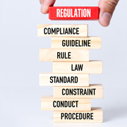 Stack of wooden blocks with words like Regulation, Rule and Compliance.