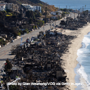 Vehicles run on the Palisades section of Pacific Coast Highway along scorched structures and trees by wildfires on January 12, 2025 in Los Angeles, California. (Photo by Qian Weizhong/VCG via Getty Images)