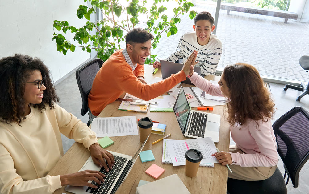 Interns at a table with laptops